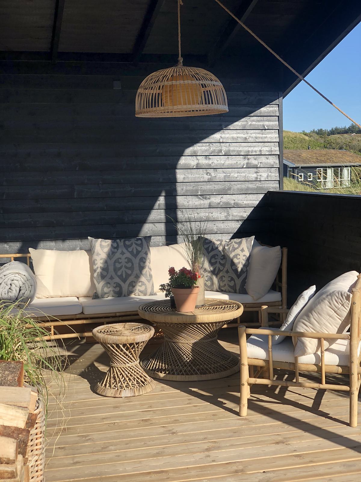 Overdækket terrasse med loungemøbler og hængelampe